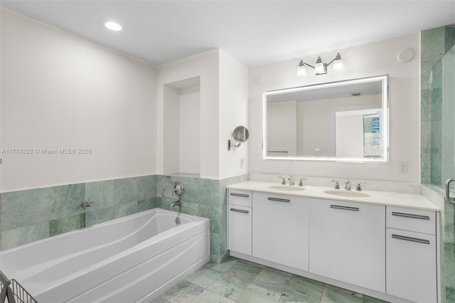 full bathroom featuring double vanity, a sink, and a garden tub