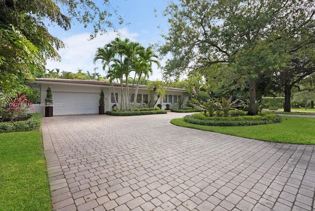 1523 Blue Rd, Coral Gables, FL 33146 - ranch-style house featuring decorative driveway, a garage, a front lawn, and stucco siding