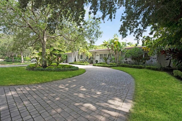 1523 Blue Rd, Coral Gables, FL 33146 - view of community with curved driveway, a yard, and a garage