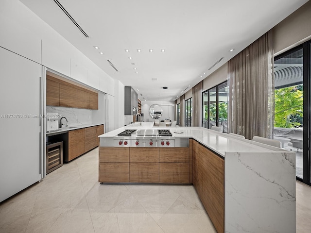 5700 SW 91st St, Pinecrest, FL 33156 - kitchen with plenty of natural light, brown cabinetry, modern cabinets, and wine cooler