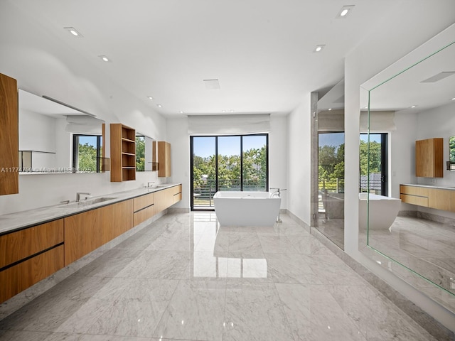 5700 SW 91st St, Pinecrest, FL 33156 - full bathroom featuring double vanity, marble tiled flooring, plenty of natural light, a freestanding tub, and recessed lighting