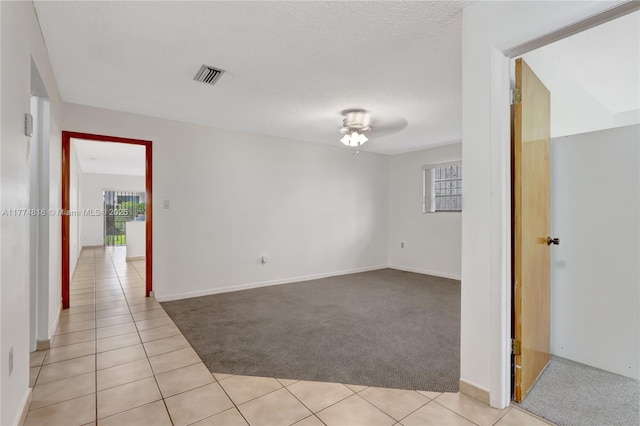 unfurnished room featuring plenty of natural light, visible vents, light tile patterned flooring, and light carpet