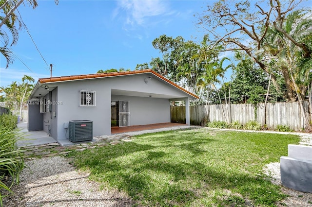 back of property featuring a yard, fence, cooling unit, a patio, and stucco siding