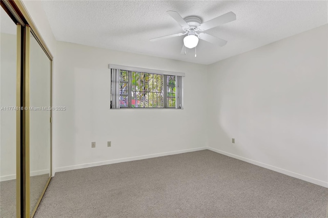 unfurnished bedroom with baseboards, carpet flooring, a closet, and a textured ceiling