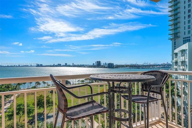 balcony with a water view and a view of city