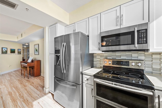 kitchen featuring light countertops, white cabinetry, stainless steel appliances, and visible vents
