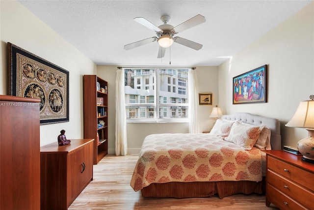 bedroom featuring light wood-style floors, baseboards, and ceiling fan