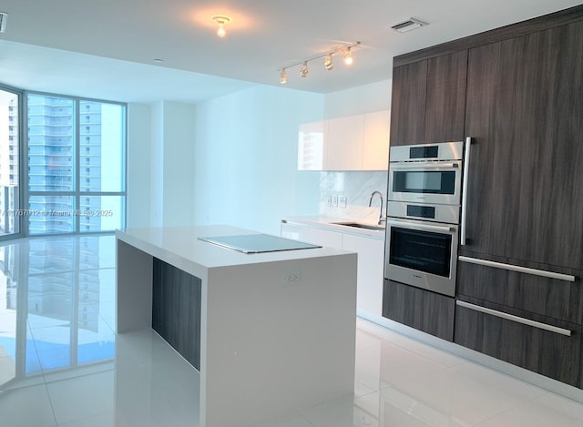 851 NE 1st Ave Unit 3905, Miami, FL 33132 - kitchen featuring visible vents, black electric cooktop, modern cabinets, a sink, and stainless steel double oven