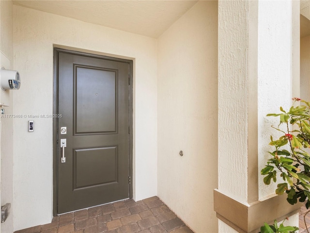 entrance to property featuring stucco siding