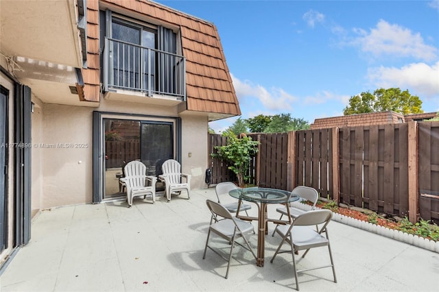 view of patio with outdoor dining space and fence