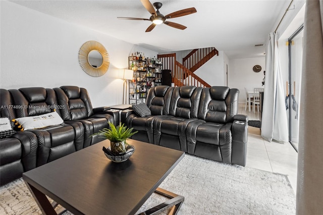 living room with stairs, light tile patterned floors, and a ceiling fan