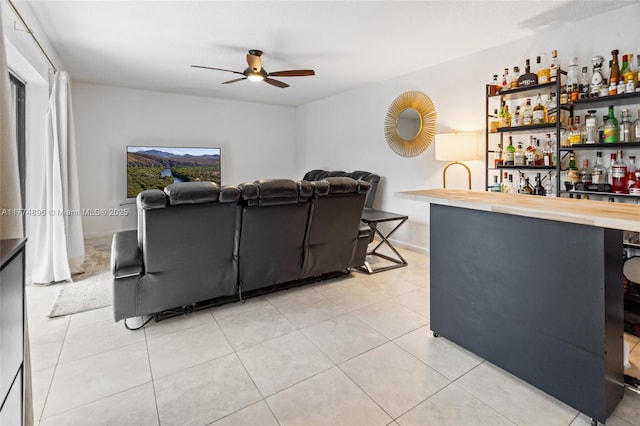 living area featuring light tile patterned floors, ceiling fan, a dry bar, and a wealth of natural light