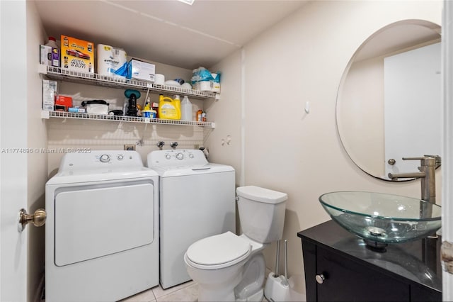half bath featuring tile patterned flooring, vanity, washer and clothes dryer, and toilet