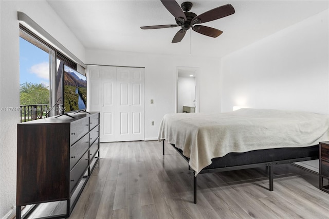 bedroom with access to exterior, ceiling fan, and wood finished floors