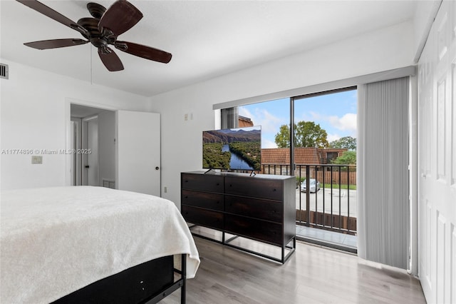 bedroom featuring access to outside, wood finished floors, ceiling fan, and visible vents