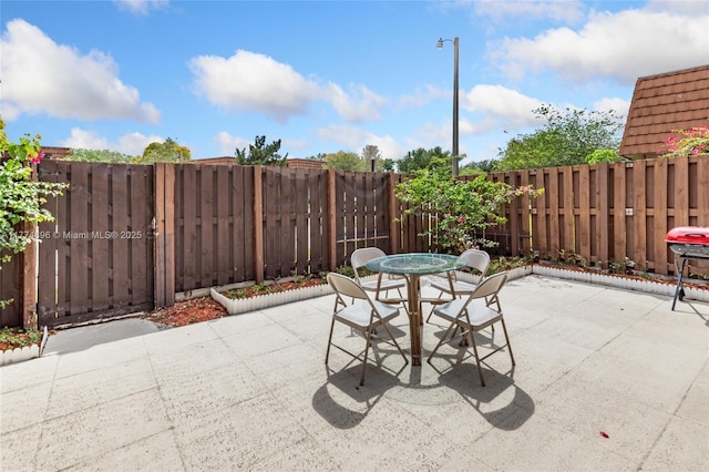 view of patio / terrace featuring grilling area, outdoor dining space, and a fenced backyard