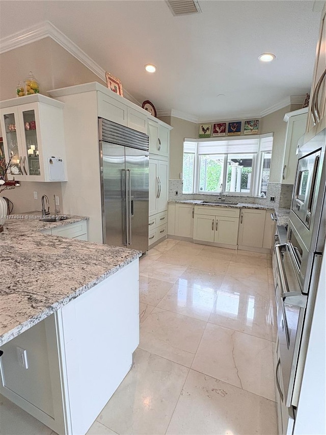 14261 SW 30th St, Miami, FL 33175 - kitchen with built in appliances, crown molding, decorative backsplash, light stone counters, and glass insert cabinets