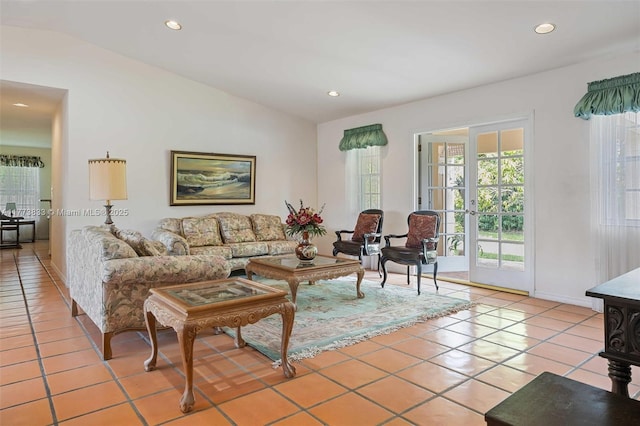 living area with lofted ceiling, light tile patterned floors, and a wealth of natural light