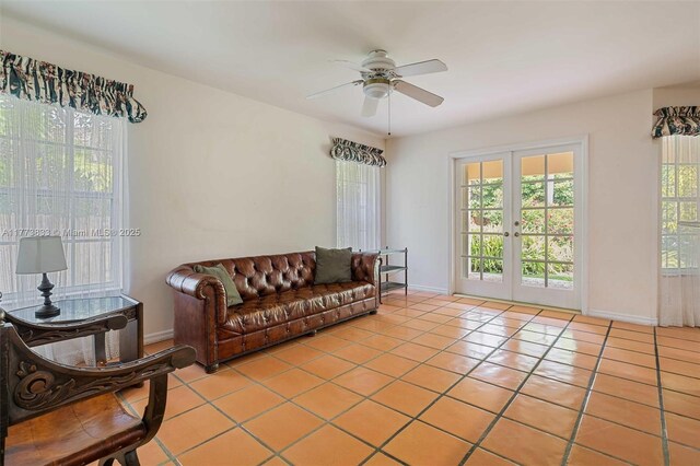 living room featuring light tile patterned floors, baseboards, a ceiling fan, and french doors