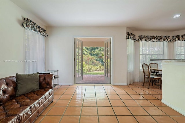 living room with baseboards, light tile patterned floors, and a healthy amount of sunlight