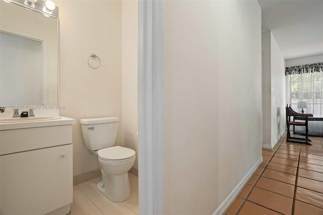 bathroom with vanity, tile patterned flooring, baseboards, and toilet