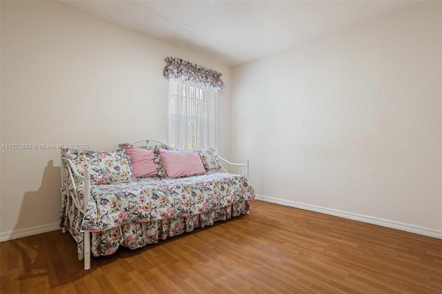 bedroom featuring baseboards and wood finished floors