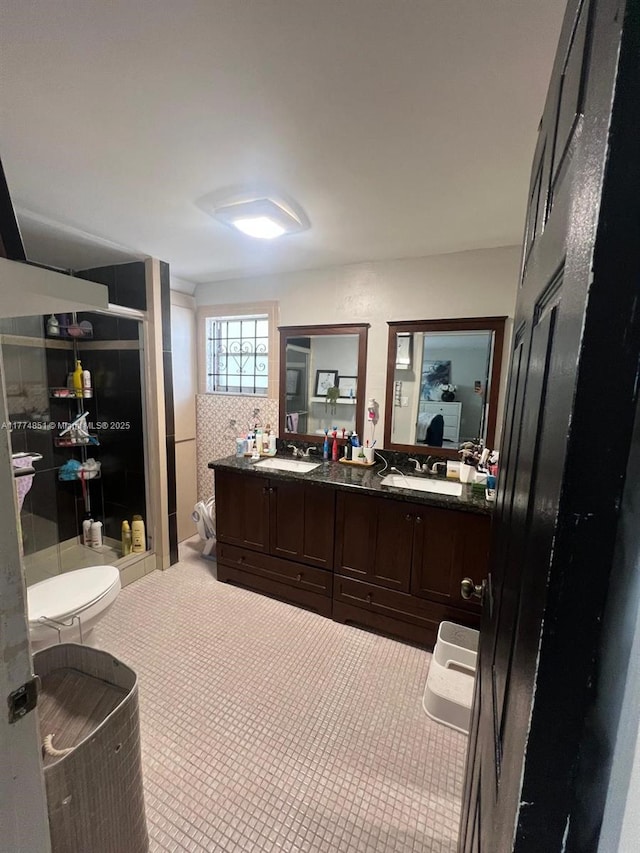 bathroom featuring double vanity, a sink, a stall shower, and ensuite bathroom