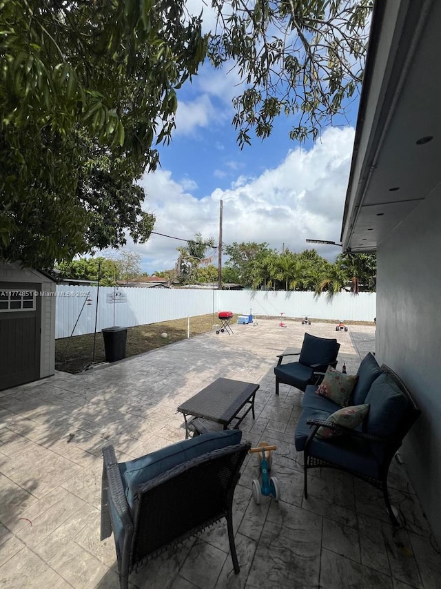 view of patio / terrace featuring a fenced backyard, an outbuilding, and a storage shed