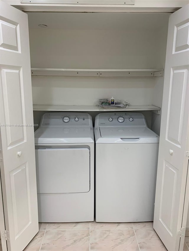washroom featuring washer and dryer, laundry area, and marble finish floor