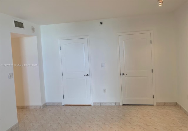 spare room with baseboards and visible vents