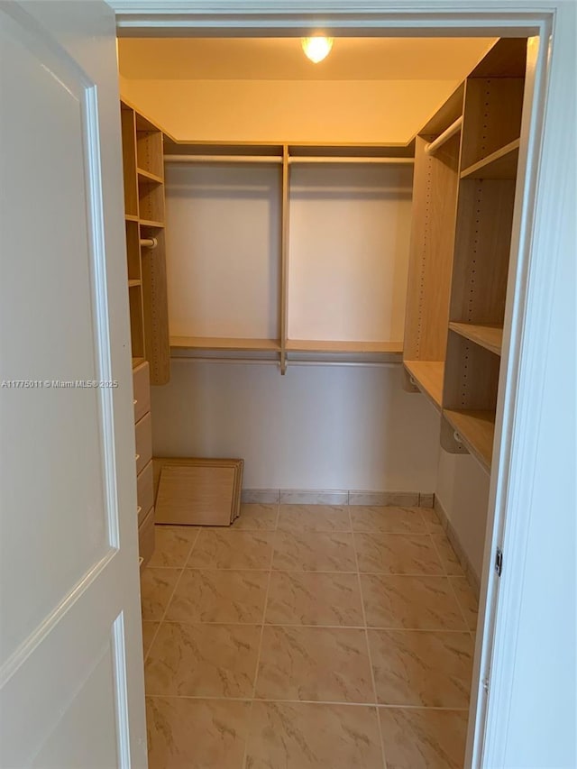 spacious closet with marble finish floor
