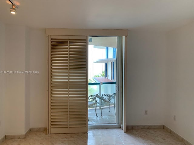 doorway to outside featuring tile patterned flooring and baseboards