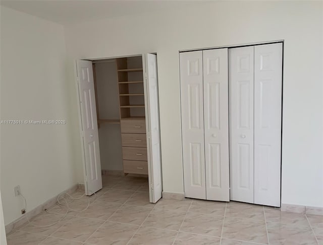 unfurnished bedroom with light tile patterned floors and baseboards