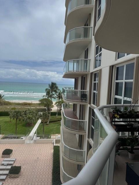 balcony featuring a water view and a view of the beach