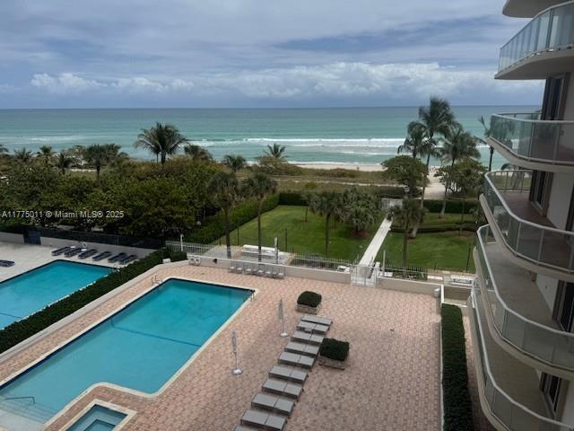 pool featuring a water view and a patio