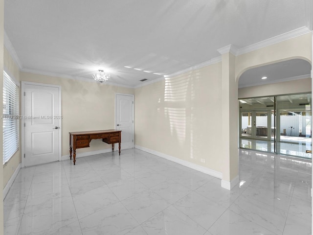 spare room featuring arched walkways, marble finish floor, ornamental molding, and baseboards