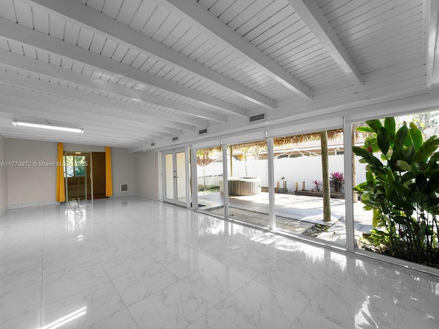 spare room featuring plenty of natural light, visible vents, and beam ceiling