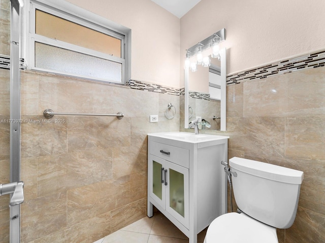 bathroom featuring tile patterned floors, toilet, tile walls, and vanity