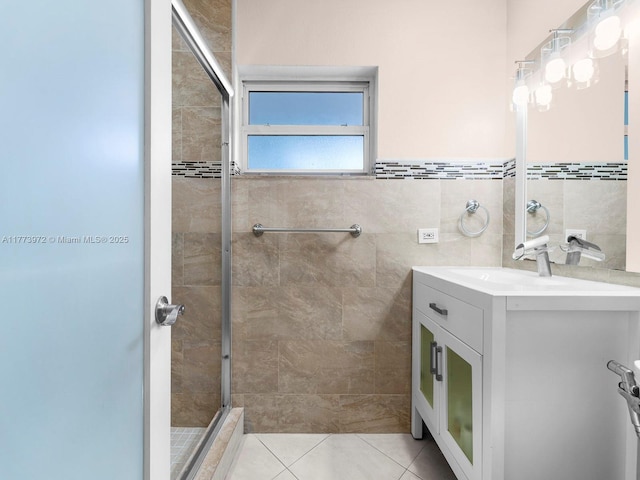 bathroom featuring tile walls, vanity, tile patterned flooring, and a shower stall