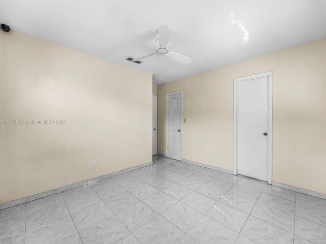 unfurnished room with a ceiling fan, baseboards, and visible vents