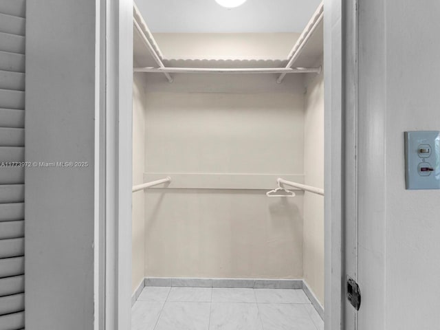 spacious closet featuring marble finish floor