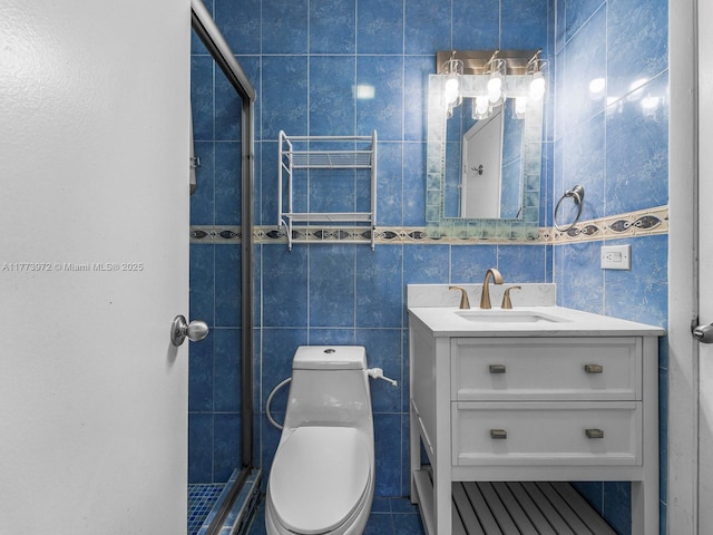 bathroom featuring toilet, vanity, a stall shower, and tile walls