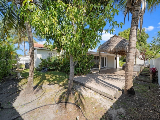 rear view of property with fence, stucco siding, a patio area, and central AC
