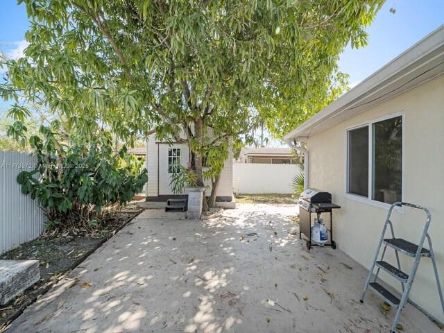 view of patio / terrace featuring an outdoor structure, area for grilling, and fence