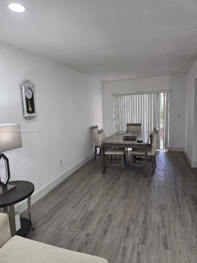 dining space featuring baseboards and wood finished floors