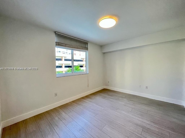 empty room featuring baseboards and wood finished floors
