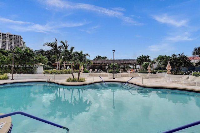 community pool featuring fence and a patio