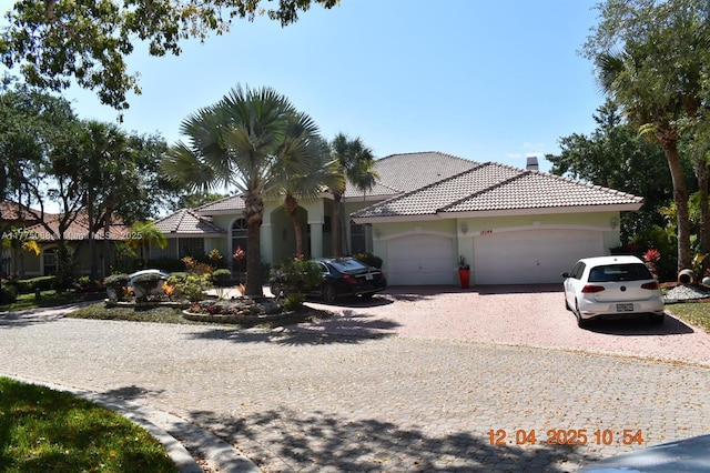 12044 NW 9th Pl, Coral Springs, FL 33071 - view of front of home with gravel driveway, stucco siding, an attached garage, and a tile roof