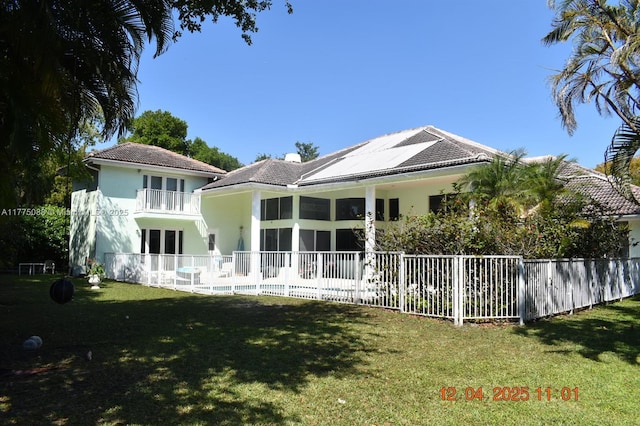 12044 NW 9th Pl, Coral Springs, FL 33071 - rear view of house featuring a tiled roof, stucco siding, a lawn, fence, and a balcony