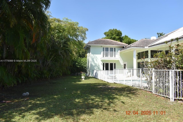 12044 NW 9th Pl, Coral Springs, FL 33071 - rear view of property featuring a balcony, fence, a lawn, and a tile roof